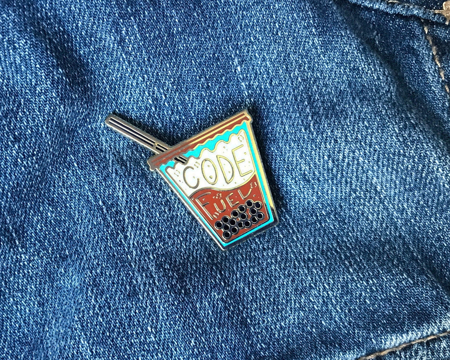 Enamel pin on a blue denim background