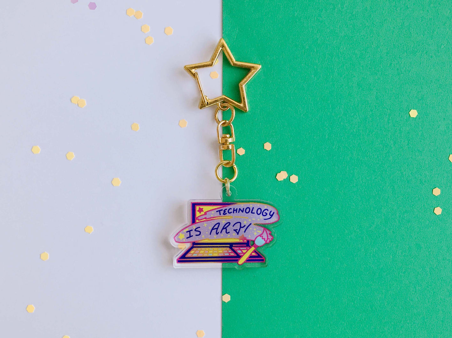Star-shaped keychain with 'Technology is Art' charm on a green and purple background